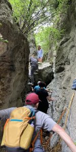 Walking the first ladder of the Perinou Canyon with a Nomia day trip